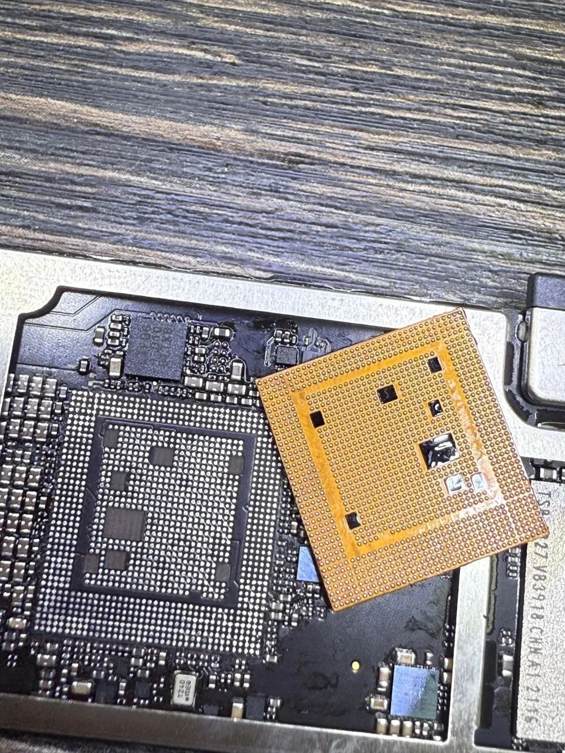 The main chip lifted off a device's logic board, showing the solder pads underneath.