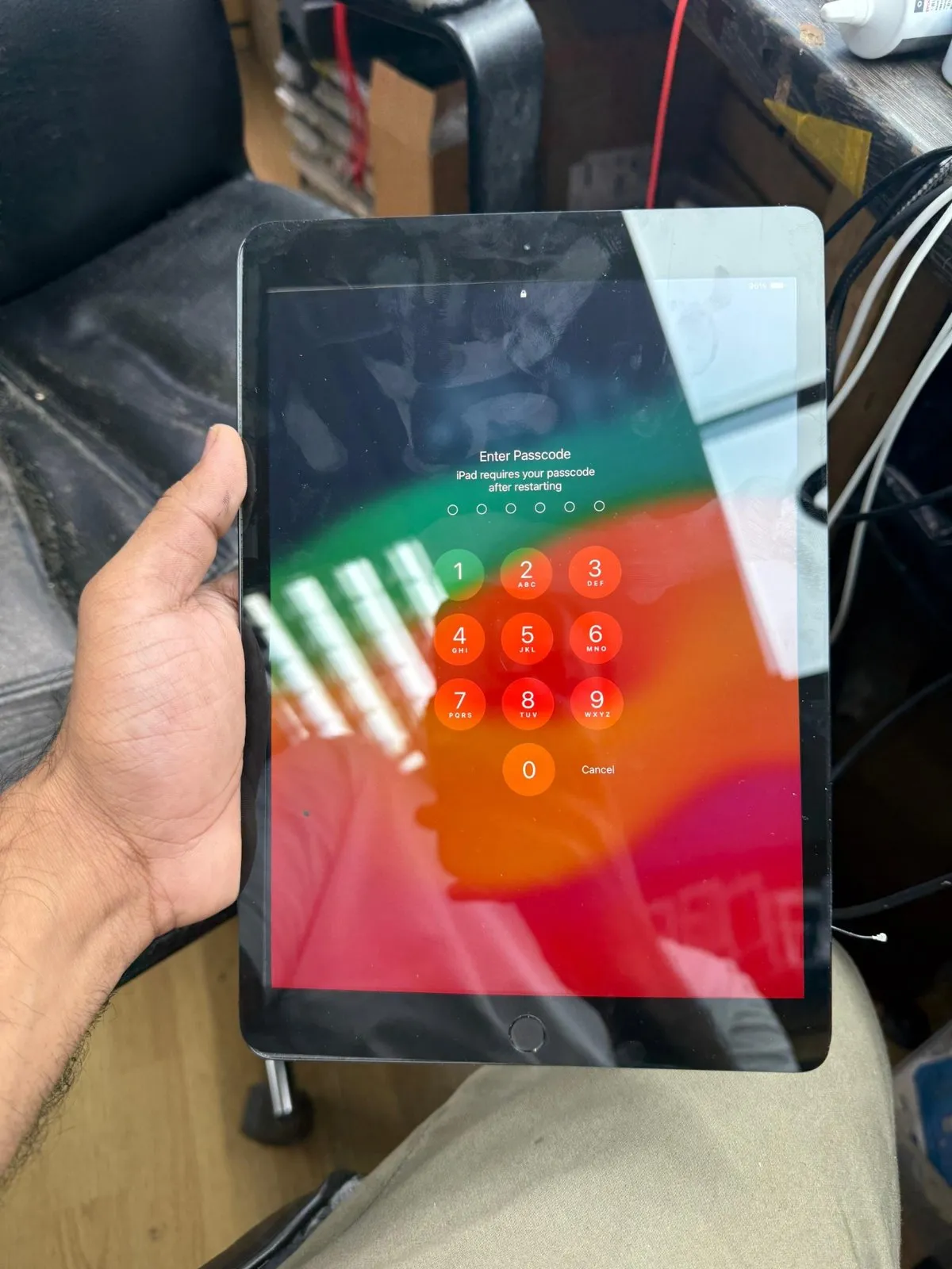 An iPad switched on and showing its Enter Passcode screen after restarting.
