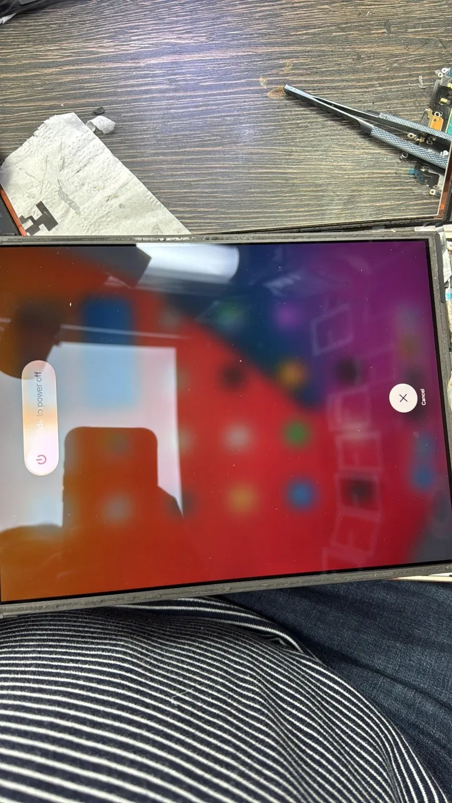 An opened iPad on the bench, switched on and showing the slide to power off screen.