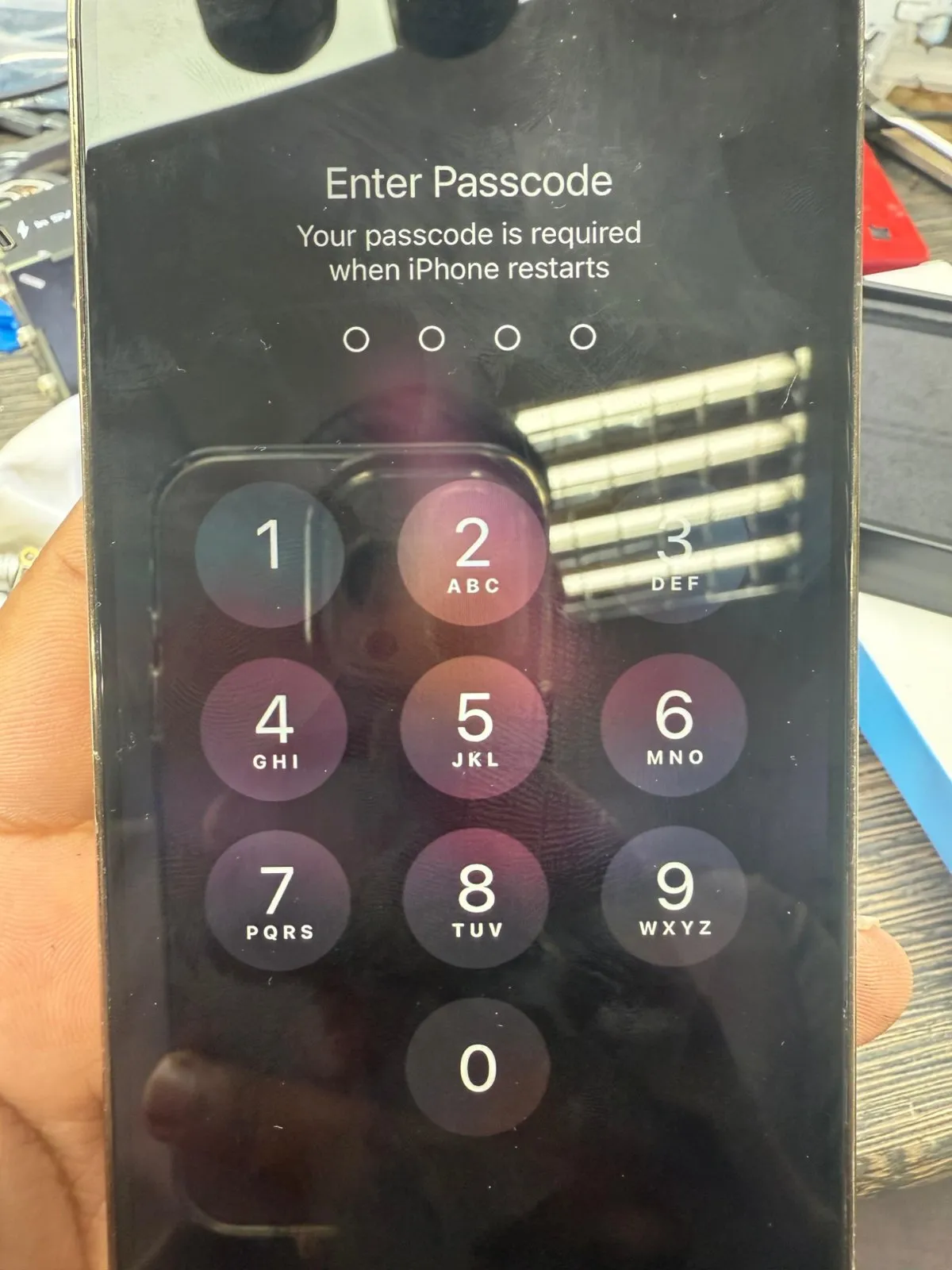 An iPhone switched on and showing its Enter Passcode screen after restarting.